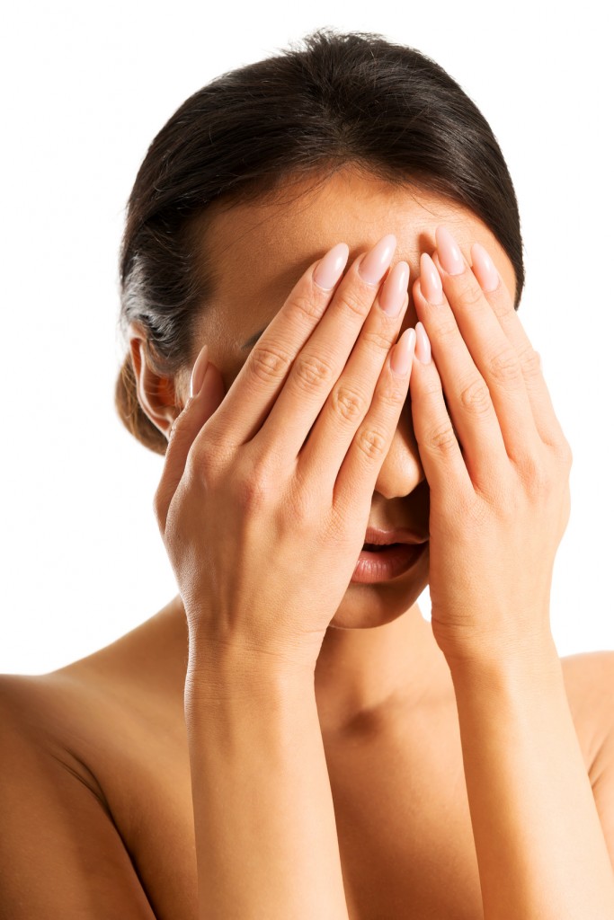 Nude woman covering her eyes because of shame